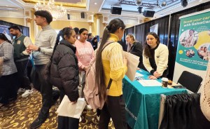 Job-seeking individuals eager to ask questions at an exhibitor booth.